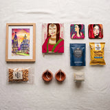 Lore Mehfil Diwali hamper contents – framed art print, art journal, two coasters, scented candle, popcorn, waffle chips, cashews and diyas
